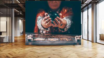 Tarot reader with tarot cards.Tarot cards face down on table near burning candles and crystal ball. Wall mural