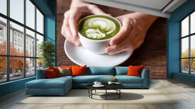 hand holding matcha green tea latter  Wall mural