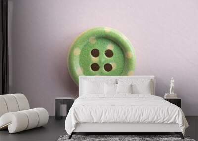 Isolated wooden button with colored colorful dots on a light pink background Wall mural