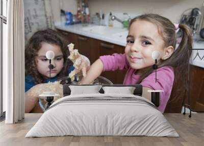 Two lovely girls mixing dough with hands Wall mural