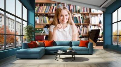 happy female student with laptop in library Wall mural