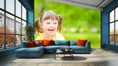 Portrait of a joyful little girl with syndrome down in a summer park. Empty space for text Wall mural