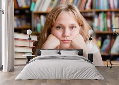 Sad female student in library looking at camera Wall mural