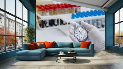  lab technician holding blood tube test and clock Wall mural