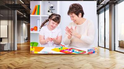 Girl with Down Syndrome works with her teacher at home Wall mural