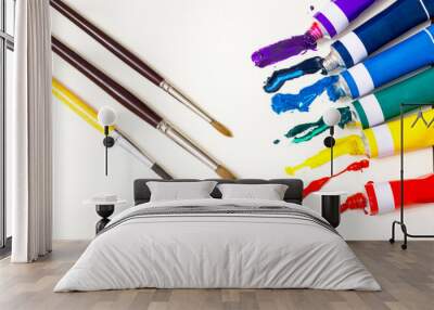 Colorful tubes of paints with brushes isolated on whites Wall mural