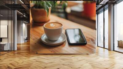 A cup of cappuccino on a coffee house bistro table in the sunshine with phone Wall mural