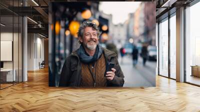 Elderly man using smatphone at the street and smiling Wall mural