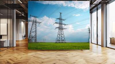 High voltage lines and power pylons in a flat and green agricultural landscape on a sunny day with clouds in the blue sky. Cloudy and rainy. Wheat is growing Wall mural