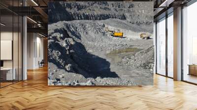 Excavator and mining truck at the bottom of the quarry, top view. Wall mural