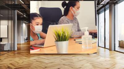 mom working at home with her child on the table while writing an report. woman working from home, while in quarantine isolation during the Covid-19 health crisis Wall mural