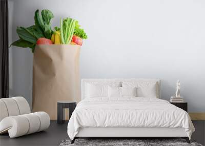 Paper bag with healthy food over white background Wall mural