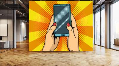 Hands holding smartphone pop art. Female hands hold a mobile phone. Vector illustration. Wall mural