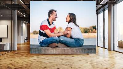 Young happy couple in jeans having fun and laughing Wall mural