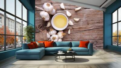 Glass bottle of garlic oil and Ripe and fresh garlic plant on wooden or rustic table, alternative medicine, organic cleaner. Wall mural