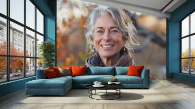 A woman with gray hair is smiling and wearing a scarf Wall mural