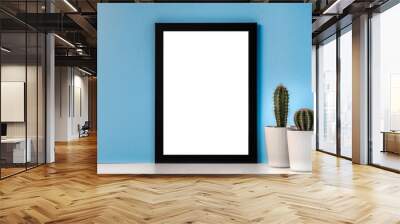 Black empty mockup frame on a blue background with two cacti Wall mural