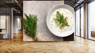 Cold cucumber soup with natural yoghurt and fresh dill on a white plate Wall mural