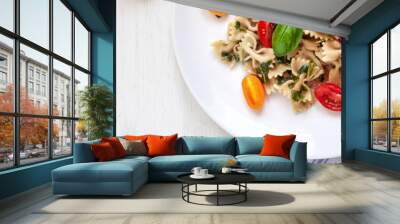 Panoramic view from above on wooden mockup table, white plate with farfalle aglio olio pasta, cherry tomatoes and fresh basil Wall mural