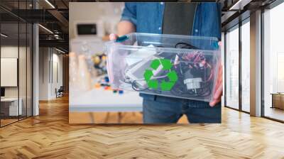 Recycling concept. An electronic waste in recycling contaner close-up. Responsible man is protecting environment while sorting the waste at home Wall mural