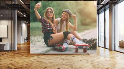 two slim and sexy young women and roller skates. one female has an inline skates and the other has a Wall mural