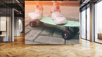 young skater girl in pink slip on shoes ride colorful tiny skateboard deck outdoors in summer.sunlig Wall mural