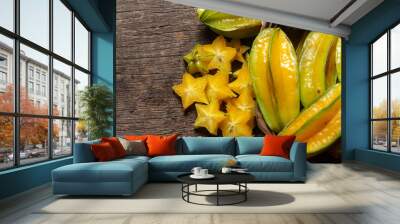 organic carambola asian fruit, star fruit, grown on organic farm in a wicker basket on a rustic wooden table top view with space for writing Wall mural