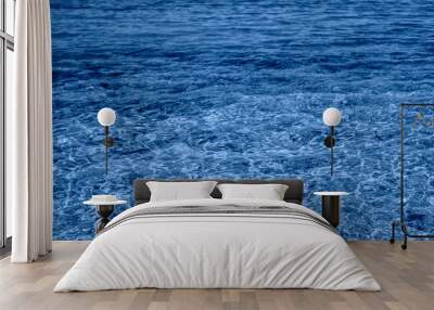 Sea water background. Ripples on blue transparent water in sea with sun reflection. Wall mural