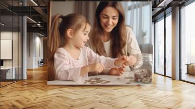 Happy little girl and mom saving money into piggy bank, saving money concept at home Wall mural