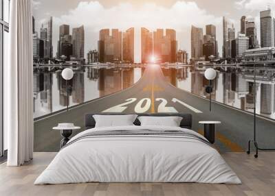 The number 2021 symbol represents the new year on the road heading to the city with beautiful skyscrapers background, New Year's and business target concepts. Wall mural