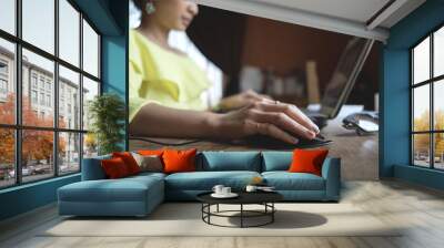 Close up of a woman hands working with a laptop and a mouse in a home interior or on desk wood beside window light shade Wall mural