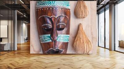 Tribal african mask with nature decor elements on wooden background. Wall mural