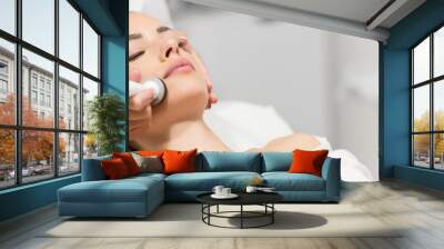 Beautiful woman in professional beauty salon during photo rejuvenation procedure Wall mural