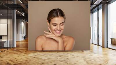 Beautiful Caucasian young woman with perfect skin touching face Wall mural