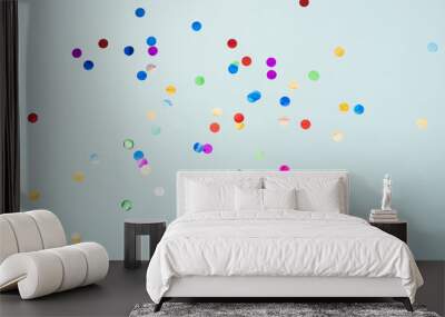 Confetti scattered on the light blue background. Bright dots on the background Wall mural