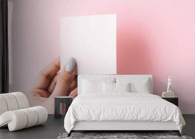 Girl's hand is holding a blank white postcard on a white background. copy space Wall mural