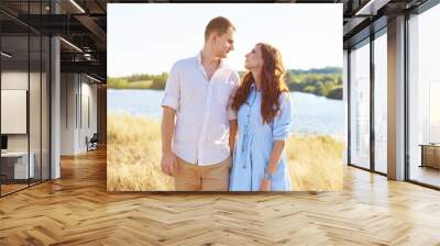 The concept of love, good relationships, understanding and harmony. Lovely young couple is walking in nature holding hands Wall mural