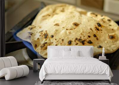 Wheat chapati or roti cooked on fire using a gas stove Wall mural