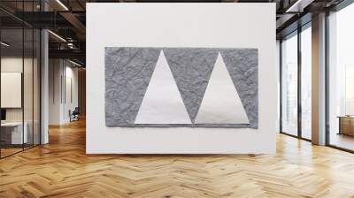 two paper triangles on textured gray paper on a blank surface Wall mural