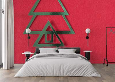 two stylized metallic foil christmas trees on red fabric and blank space Wall mural