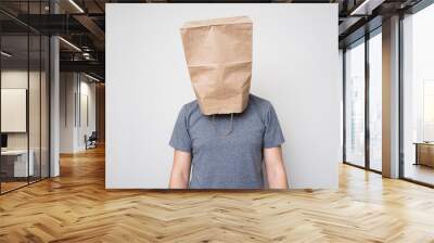 A man in a gray shirt and a paper bag on his head. Wall mural