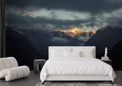 Dramatic mountain landscape in Sagarmatha National Park, Himalayas, Neplal, Dramatic sunset in mountains. Dark clouds and orange sunset lights in mountains. Wall mural