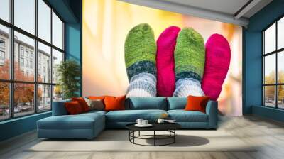 Couple in Colorful Woolen Knitted Socks Touching Each Other Feet up in the Air. People Relaxing At Home in Cold Season. Christmas, New Year, Love, Relationship, Cozy Home Concept. Wall mural