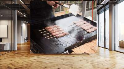 In the picture we can see a man preparing a street food. Some are prepared and kept infornt of the oven for sale. Wall mural