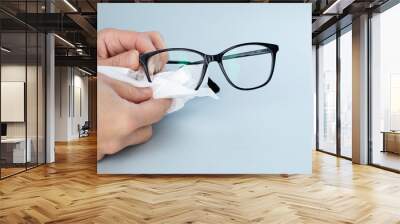 Person Cleaning Black Eyeglasses  With Special Wipes Wall mural