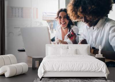 two multicultural young women having fun while watching computer Wall mural