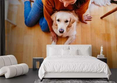 beautiful woman hugging her adorable golden retriever dog at home. love for animals concept. lifestyle indoors Wall mural