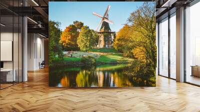 Windmill in a park with many trees and a river. Very colorful postcard Wall mural