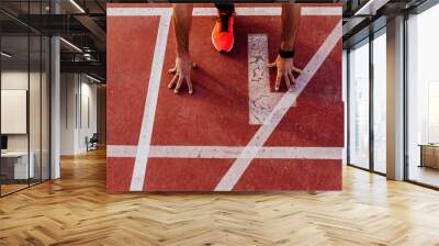 close up view of young muscular athlete is at the start of the race tracks line at the stadium. Sports concept Wall mural