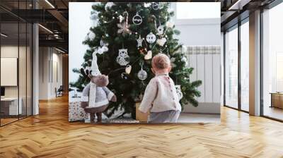 cute baby girl decorating the Christmas tree Wall mural